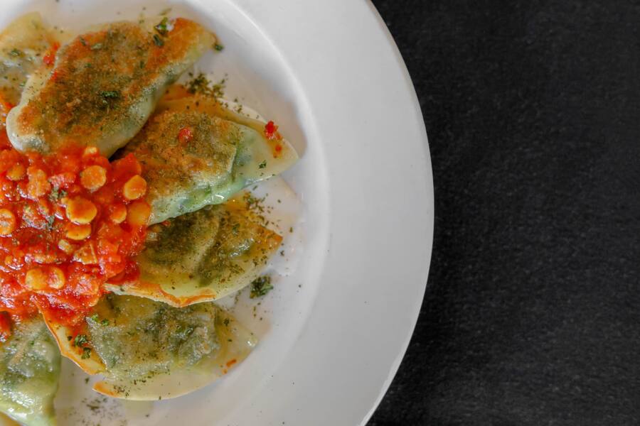 Pan-crisped three-mushroom mantu topped with tomato ragù and saffron yogurt cream